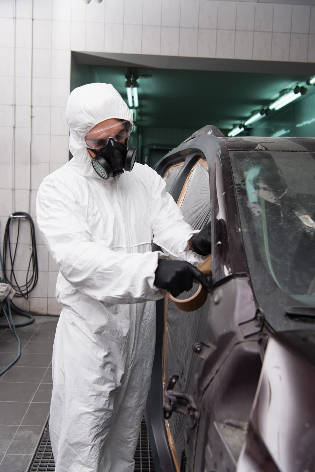 Technician in protective overalls masking a car before respray at Cool Cars, Swanmore, SO32 2PB
